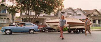 Movie still from “Pineapple Express” (2008), directed by David Gordon Green – A man walking down a street holding a bag; Wide shot, Low angle