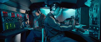 Movie still from “Pineapple Express” (2008), directed by David Gordon Green – Two men are sitting in a bus with headphones on; Medium shot, High angle