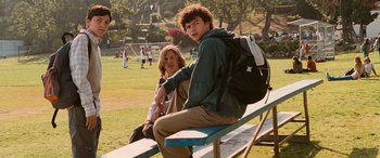 Movie still from “Pineapple Express” (2008), directed by David Gordon Green – A man and woman sitting on top of a blue bench; Medium shot, Low angle