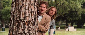 Movie still from “Pineapple Express” (2008), directed by David Gordon Green – Two young men standing next to a tree in a park; Medium shot, Low angle