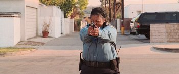 Movie still from “Pineapple Express” (2008), directed by David Gordon Green – A police officer holding a gun in her hand; Medium shot, Low angle