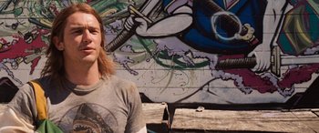Movie still from “Pineapple Express” (2008), directed by David Gordon Green – A man standing in front of a graffiti wall; Close Up shot, Low angle