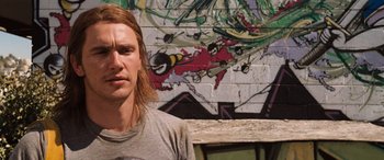 Movie still from “Pineapple Express” (2008), directed by David Gordon Green – A man standing in front of a graffiti wall; Close Up shot, Low angle