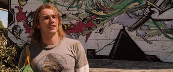 Movie still from “Pineapple Express” (2008), directed by David Gordon Green – A man standing in front of a graffiti wall; Medium shot, Low angle