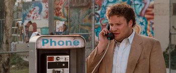 Movie still from “Pineapple Express” (2008), directed by David Gordon Green – A man talking on a phone next to an old payphone; Medium shot, Low angle