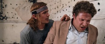 Movie still from “Pineapple Express” (2008), directed by David Gordon Green – A man wearing a headband is talking to another man in a suit; Medium shot, Over the shoulder angle