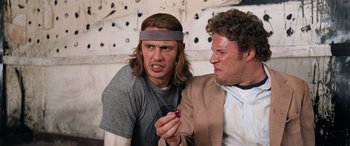 Movie still from “Pineapple Express” (2008), directed by David Gordon Green – A man holding a cell phone next to another man; Close Up shot, Low angle