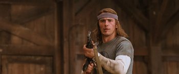 Movie still from “Pineapple Express” (2008), directed by David Gordon Green – A man holding a gun while standing in a room; Close Up shot, Over the shoulder angle