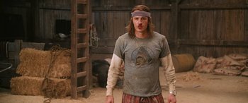 Movie still from “Pineapple Express” (2008), directed by David Gordon Green – A man with long blonde hair wearing a headband; Medium shot, Over the shoulder angle