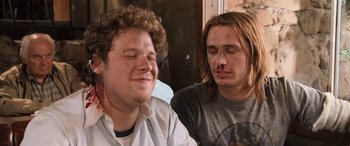 Movie still from “Pineapple Express” (2008), directed by David Gordon Green – Two men sitting next to each other on a bench; Close Up shot, Over the shoulder angle
