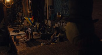 Movie still from “Pinocchio” (2022), directed by Robert Zemeckis – A room filled with lots of clutter and a large window; Wide shot, High angle