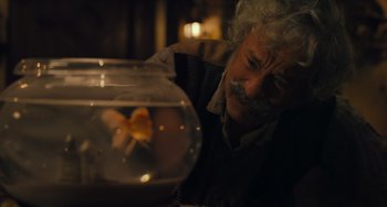 Movie still from “Pinocchio” (2022), directed by Robert Zemeckis – An older man looking at a fish in a bowl; Close Up shot, High angle