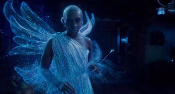 Movie still from “Pinocchio” (2022), directed by Robert Zemeckis – A woman dressed as a fairy holding a violin; Medium shot, Low angle