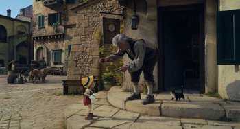 Movie still from “Pinocchio” (2022), directed by Robert Zemeckis – An old man and a young boy are standing on the steps; Wide shot, Low angle