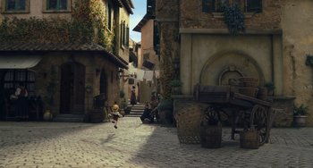 Movie still from “Pinocchio” (2022), directed by Robert Zemeckis – An animated scene of a small town with people sitting and standing around it; Extreme Wide shot, High angle