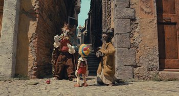 Movie still from “Pinocchio” (2022), directed by Robert Zemeckis – A group of people dressed up like animals; Wide shot, High angle