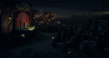 Movie still from “Pinocchio” (2022), directed by Robert Zemeckis – A group of people sitting in a dark room; Extreme Wide shot, Low angle