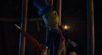 Movie still from “Pinocchio” (2022), directed by Robert Zemeckis – A frog wearing a top hat and holding an umbrella; Medium shot, Low angle