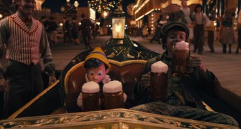 Movie still from “Pinocchio” (2022), directed by Robert Zemeckis – Two people sitting in a chair holding beer mugs; Medium shot, High angle