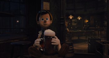 Movie still from “Pinocchio” (2022), directed by Robert Zemeckis – A person sitting in a room holding a beer; Medium shot, Over the shoulder angle