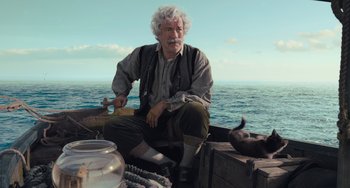 Movie still from “Pinocchio” (2022), directed by Robert Zemeckis – An older man sitting on a boat in the water; Medium shot, Low angle