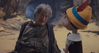Movie still from “Pinocchio” (2022), directed by Robert Zemeckis – An older man and a child in a cave; Medium shot, Over the shoulder angle