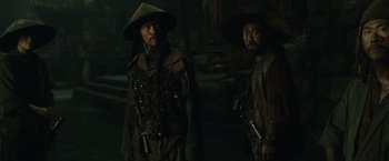 Movie still from “Pirates of the Caribbean: At World's End” (2007), directed by Gore Verbinski – Two asian men standing next to each other in a dark room; Medium shot, Low angle