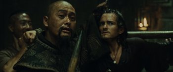 Movie still from “Pirates of the Caribbean: At World's End” (2007), directed by Gore Verbinski – A man holding a baseball bat next to another man; Close Up shot, Over the shoulder angle