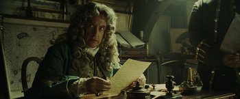 Movie still from “Pirates of the Caribbean: At World's End” (2007), directed by Gore Verbinski – An old man in a wig is writing on a piece of paper; Medium shot, Over the shoulder angle