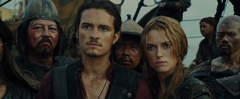 Movie still from “Pirates of the Caribbean: At World's End” (2007), directed by Gore Verbinski – A man and a woman standing next to each other in front of another man; Close Up shot, Over the shoulder angle