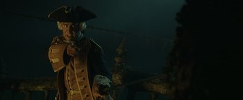 Movie still from “Pirates of the Caribbean: At World's End” (2007), directed by Gore Verbinski – A man in a pirate costume standing in front of a ship; Medium shot, Low angle