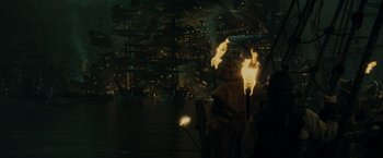 Movie still from “Pirates of the Caribbean: At World's End” (2007), directed by Gore Verbinski – A person holding a lit up umbrella in front of a city at night; Extreme Wide shot, High angle