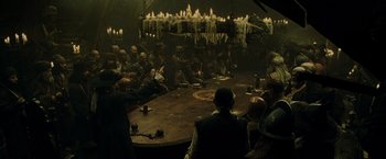 Movie still from “Pirates of the Caribbean: At World's End” (2007), directed by Gore Verbinski – A group of people sitting around a round table; Wide shot, High angle