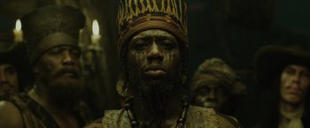 Movie still from “Pirates of the Caribbean: At World's End” (2007), directed by Gore Verbinski – A man with a beard wearing a crown and a necklace; Close Up shot, Low angle