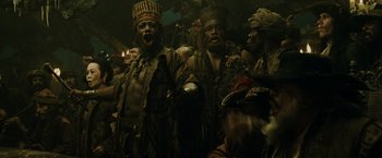 Movie still from “Pirates of the Caribbean: At World's End” (2007), directed by Gore Verbinski – A group of men in costumes are standing in a room; Medium shot, Low angle