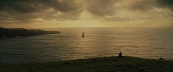Movie still from “Pirates of the Caribbean: At World's End” (2007), directed by Gore Verbinski – Two people sit on a hill overlooking the ocean; Extreme Wide shot, Low angle