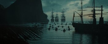 Movie still from “Pirates of the Caribbean: Dead Man's Chest” (2006), directed by Gore Verbinski – A group of boats in the water near the shore; Extreme Wide shot, High angle
