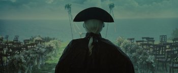 Movie still from “Pirates of the Caribbean: Dead Man's Chest” (2006), directed by Gore Verbinski – A person wearing a hat and a cape looking out a window at the ocean; Close Up shot, Over the shoulder angle