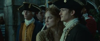 Movie still from “Pirates of the Caribbean: Dead Man's Chest” (2006), directed by Gore Verbinski – A man and a woman are standing next to each other in front of a crowd; Close Up shot, Over the shoulder angle