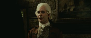 Movie still from “Pirates of the Caribbean: Dead Man's Chest” (2006), directed by Gore Verbinski – A man in a wig standing in front of a brick wall; Close Up shot, Low angle