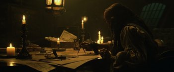 Movie still from “Pirates of the Caribbean: Dead Man's Chest” (2006), directed by Gore Verbinski – A person sitting at a table with a laptop; Medium shot, High angle