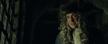 Movie still from “Pirates of the Caribbean: Dead Man's Chest” (2006), directed by Gore Verbinski – An old man in a wig and a hat; Close Up shot, Over the shoulder angle