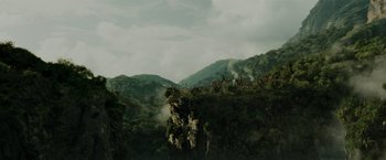 Movie still from “Pirates of the Caribbean: Dead Man's Chest” (2006), directed by Gore Verbinski – A view of a mountain range with trees in the foreground; Extreme Wide shot, High angle