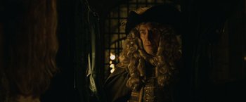 Movie still from “Pirates of the Caribbean: Dead Man's Chest” (2006), directed by Gore Verbinski – An old man with long curly hair wearing a hat; Medium shot, Over the shoulder angle