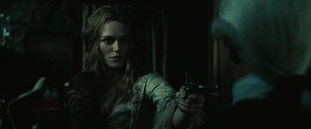 Movie still from “Pirates of the Caribbean: Dead Man's Chest” (2006), directed by Gore Verbinski – A beautiful woman holding a gun in a dark room; Close Up shot, Over the shoulder angle