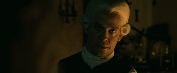 Movie still from “Pirates of the Caribbean: Dead Man's Chest” (2006), directed by Gore Verbinski – A man with a white wig is looking at the camera; Close Up shot, Over the shoulder angle
