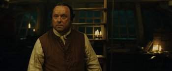 Movie still from “Pirates of the Caribbean: Dead Man's Chest” (2006), directed by Gore Verbinski – A man in a vest and tie standing next to a window; Close Up shot, Over the shoulder angle