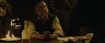Movie still from “Pirates of the Caribbean: Dead Man's Chest” (2006), directed by Gore Verbinski – An older man sitting at a table with his hands folded; Medium shot, Over the shoulder angle