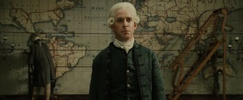 Movie still from “Pirates of the Caribbean: Dead Man's Chest” (2006), directed by Gore Verbinski – A man in a wig standing in front of a map; Medium shot, Low angle