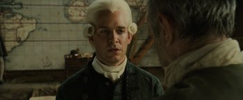 Movie still from “Pirates of the Caribbean: Dead Man's Chest” (2006), directed by Gore Verbinski – A man in a wig looking at a man in a suit; Close Up shot, Over the shoulder angle